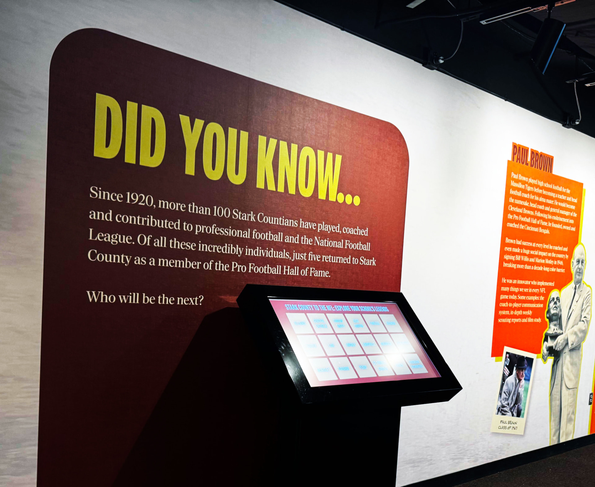 Museum information wall with large typography and an interactive display