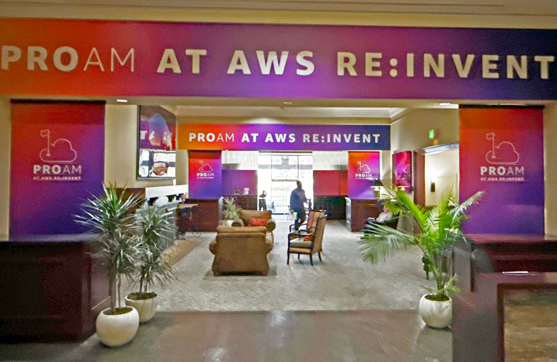 Hotel lobby wrapped in gradient printed wall and header graphics for a conference