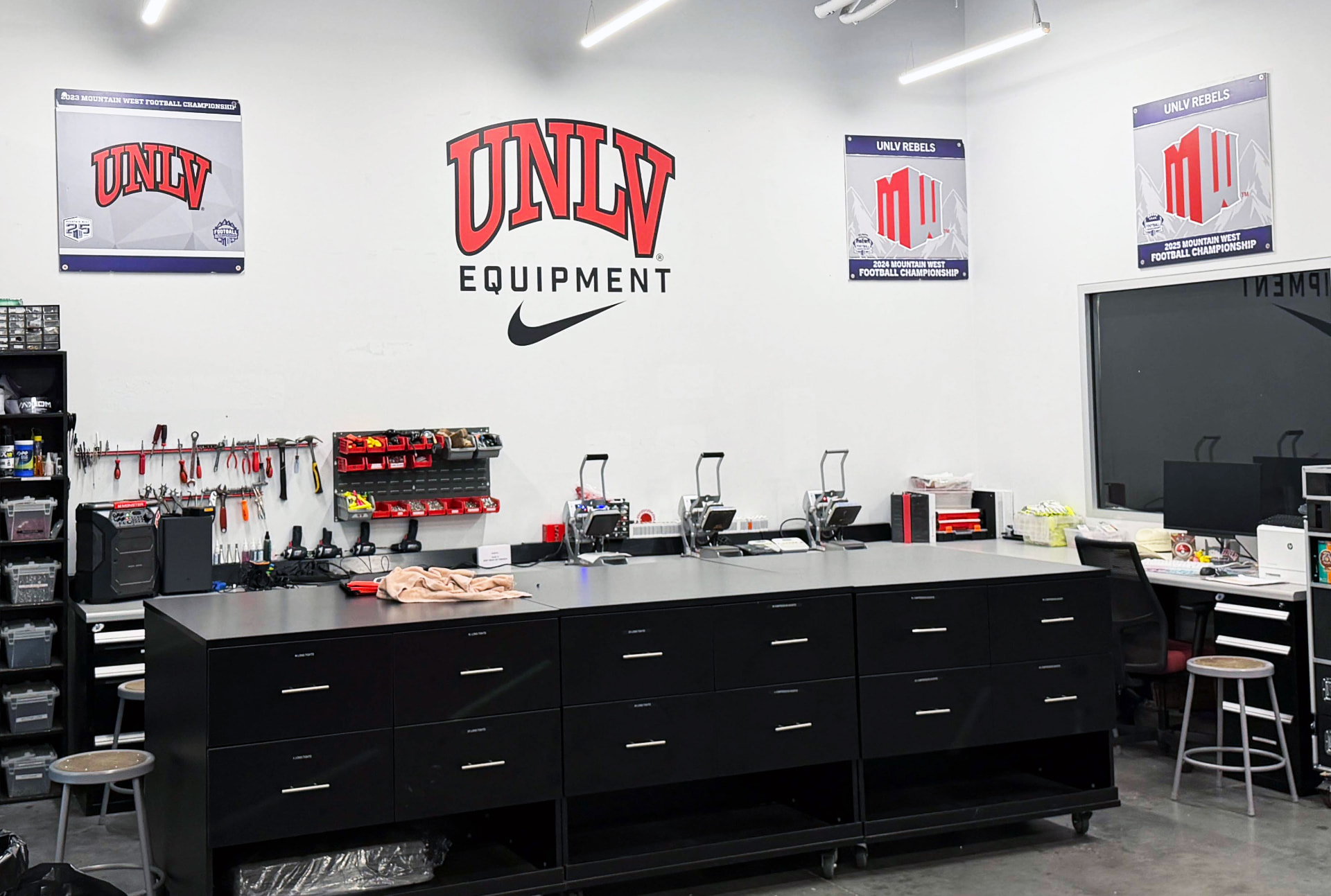 Branded interior wall graphics and framed panels above a workroom counter