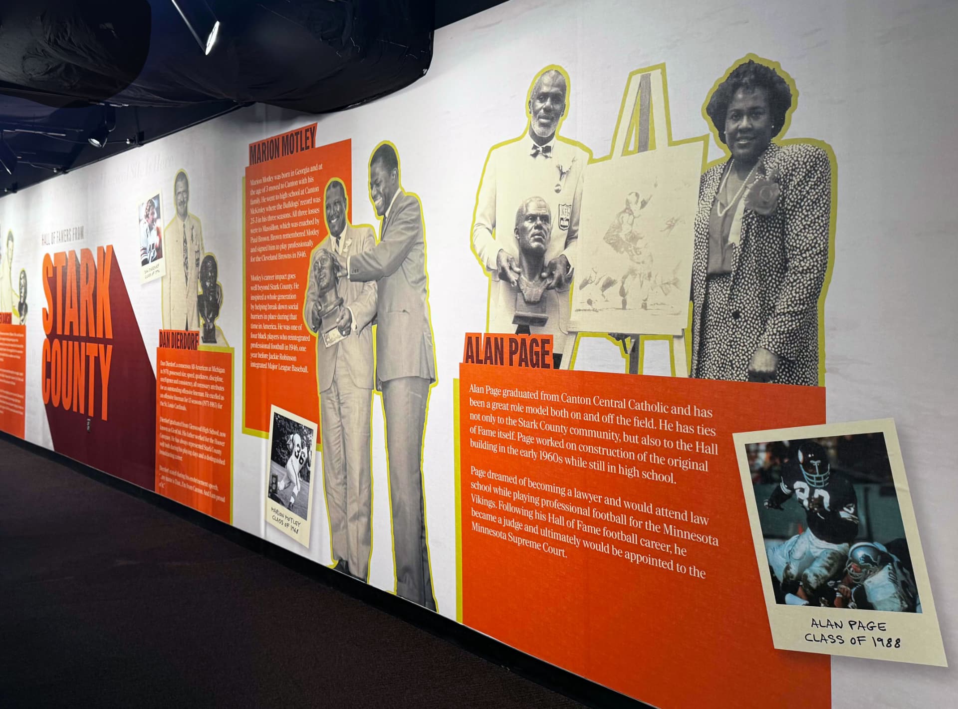 Long museum wall combining historic portraits, typography and information graphics