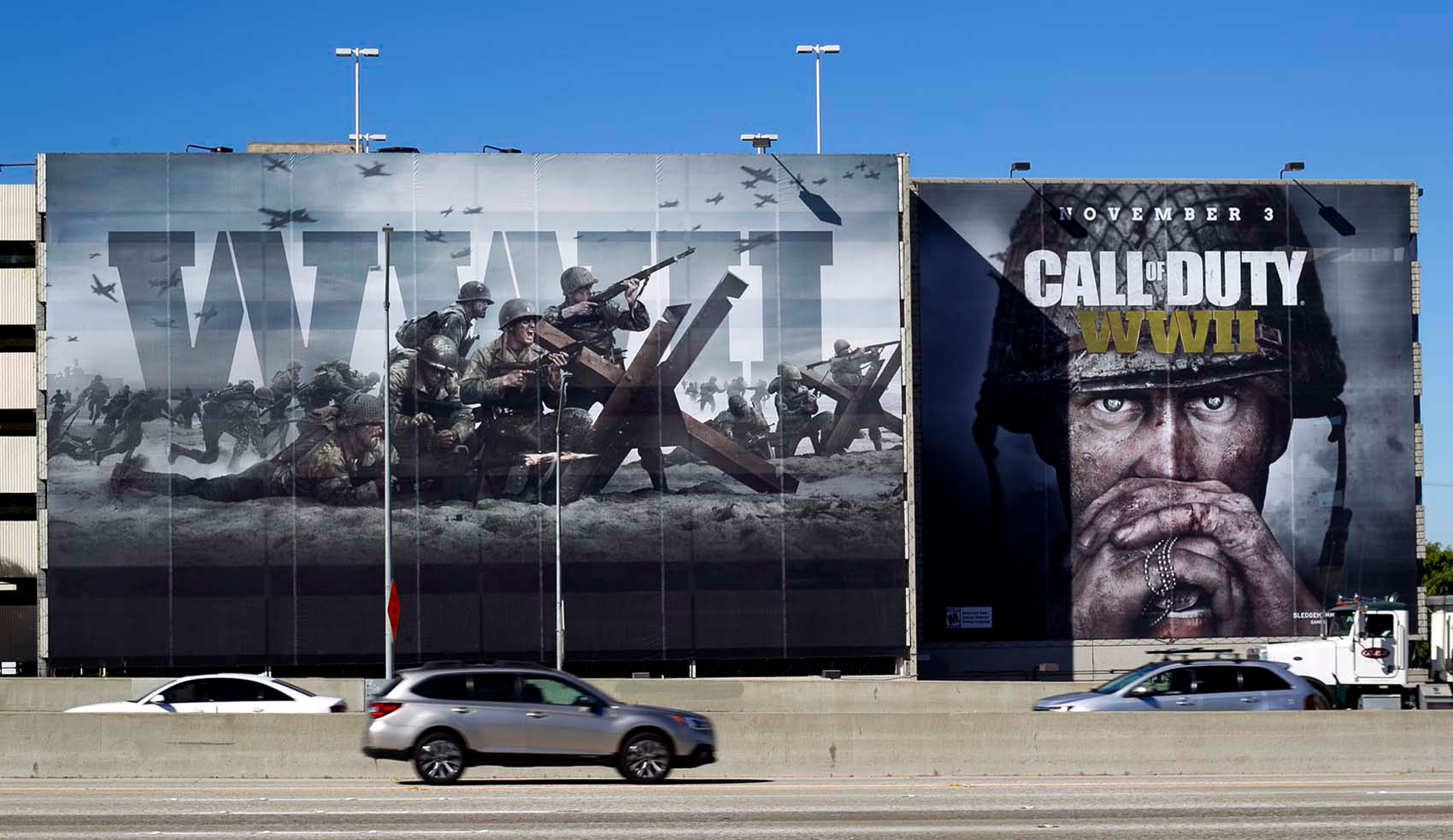 Two enormous printed building wraps covering a parking structure beside a freeway