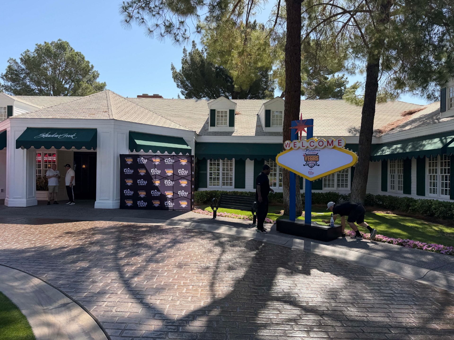 Outdoor activation with a welcome sign and a branded step-and-repeat wall at a clubhouse entry