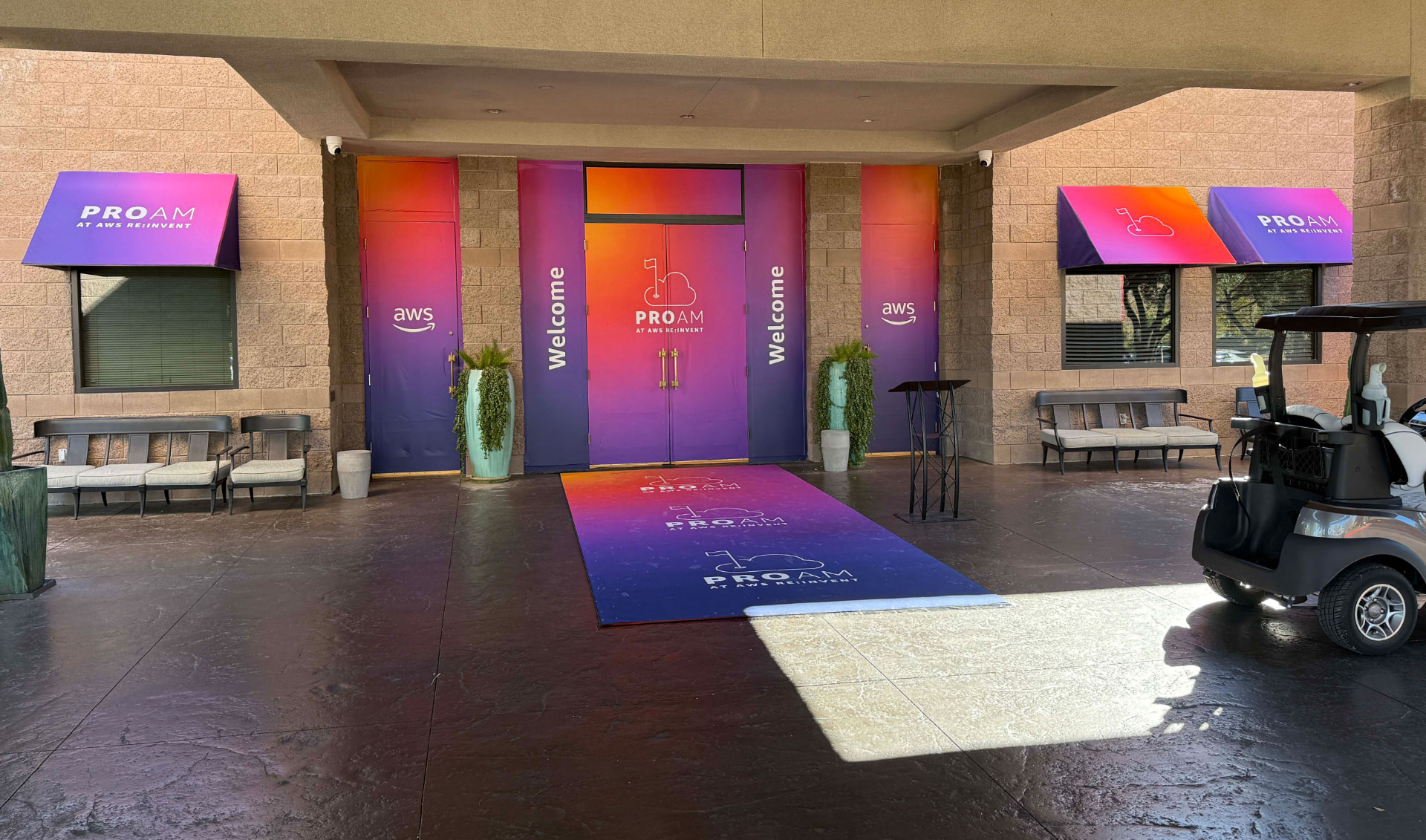 Building entrance with gradient door wraps, Welcome panels, ProAm awnings and a printed floor runner