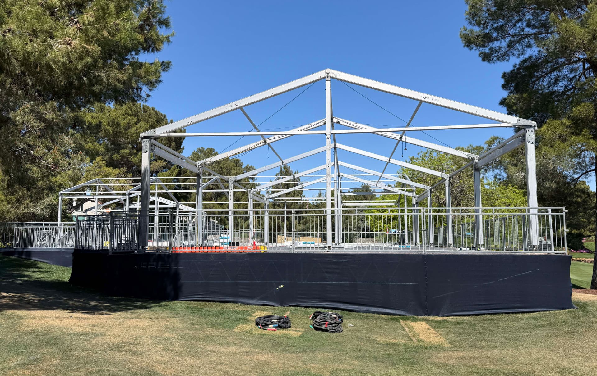 Open aluminum event structure framework on a raised platform outdoors